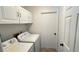 Practical laundry room with white appliances and storage cabinets at 28818 Midnight Star Loop, Wesley Chapel, FL 33543