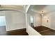 Open-concept living room with hardwood floors, archway to the entrance, and bright natural lighting at 28818 Midnight Star Loop, Wesley Chapel, FL 33543