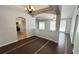 Open-concept living room with wood-look tile floors, archways, and view of the kitchen at 28818 Midnight Star Loop, Wesley Chapel, FL 33543
