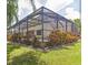 Backyard showcasing a screened-in patio with lush landscaping and an inviting outdoor space at 309 Dakota Hill Dr, Seffner, FL 33584