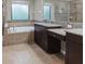 Elegant bathroom featuring a soaking tub, dual vanities with granite countertops, and a walk-in shower at 309 Dakota Hill Dr, Seffner, FL 33584