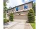 Stunning two-story home featuring an attached two-car garage, complemented by beautifully trimmed trees and shrubs at 309 Dakota Hill Dr, Seffner, FL 33584