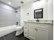 Modern bathroom featuring sleek gray tile, black fixtures, and a stylish vanity with granite countertop at 3114 Little Rd, Valrico, FL 33596