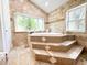 Bathroom with garden tub with mosaic accents and bright window at 3114 Little Rd, Valrico, FL 33596