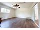 Large bedroom with rich wood flooring, a ceiling fan, and a sliding-door closet for ample storage at 3114 Little Rd, Valrico, FL 33596