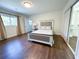 Bright bedroom featuring a large bed, wood floors, and neutral decor, creating a serene and inviting space at 3114 Little Rd, Valrico, FL 33596