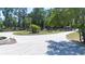 Circular driveway leading up to a home with lush landscaping, palm trees, and mature trees at 3114 Little Rd, Valrico, FL 33596