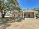 Exterior white brick home with long partially covered porch area, mature trees, and grass lawn at 3114 Little Rd, Valrico, FL 33596