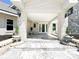 Front porch with marble floors, white brick columns, and two beautiful wall-mount lamps at 3114 Little Rd, Valrico, FL 33596