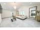 Bright living area featuring a neutral sofa, glass coffee table, and ample light at 3114 Little Rd, Valrico, FL 33596