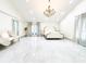 This main bedroom features a crystal chandelier, French doors, seating, and marbled tile flooring at 3114 Little Rd, Valrico, FL 33596