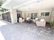 Covered outdoor seating area with brick columns, brick patio, and neutral wicker seating around a coffee table at 3114 Little Rd, Valrico, FL 33596