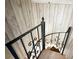 Staircase with rustic wood-paneled walls and ornate wrought iron railing at 3114 Little Rd, Valrico, FL 33596