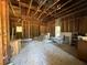 Unfinished room with exposed ceiling and walls, two windows, and debris on floor at 3114 Little Rd, Valrico, FL 33596