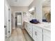 Beautiful bathroom with double sinks, quartz countertops, a walk in shower, and wood-look tile floors at 31637 Cannon Rush Dr, San Antonio, FL 33576