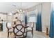 Elegant dining area with modern lighting fixture and stylish blue ombre curtains in open concept living space at 31637 Cannon Rush Dr, San Antonio, FL 33576