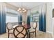 Charming dining area featuring a round wood table, four chairs, and elegant chandelier lighting at 31637 Cannon Rush Dr, San Antonio, FL 33576