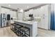 Modern kitchen featuring white cabinets, a large island with bar seating, and stainless steel appliances at 31637 Cannon Rush Dr, San Antonio, FL 33576