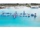 Breathtaking aerial view of the community lagoon featuring an inflatable obstacle course and white-sand beaches at 31637 Cannon Rush Dr, San Antonio, FL 33576