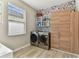 Well-lit laundry room with front-loading washer and dryer, storage shelves, and wood-look cabinets at 31637 Cannon Rush Dr, San Antonio, FL 33576
