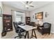 Well-lit home office with a white desk, bookcases, and comfortable seating at 31637 Cannon Rush Dr, San Antonio, FL 33576