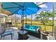 Covered screened lanai with a dining bar, outdoor seating, and relaxing backyard views at 31637 Cannon Rush Dr, San Antonio, FL 33576