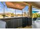 Exterior covered bar and grill area with counter seating, beverage refrigerators, and a retractable awning at 31637 Cannon Rush Dr, San Antonio, FL 33576