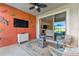 Cozy screened patio featuring a fire pit, wall mounted TV, comfortable seating, and view through sliding glass doors at 31637 Cannon Rush Dr, San Antonio, FL 33576