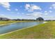 Scenic pond view with lush green grass and serene landscaping around the community at 31637 Cannon Rush Dr, San Antonio, FL 33576