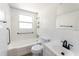Bright bathroom featuring a tub with shower, safety bars, and white tiled walls at 3253 57Th N Ave, St Petersburg, FL 33714