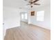 Spacious living room featuring ceiling fan, white walls, wood floors, and arched doorway at 3253 57Th N Ave, St Petersburg, FL 33714