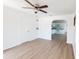 Airy living room with light wood floors, ceiling fan, and an open archway to the kitchen at 3253 57Th N Ave, St Petersburg, FL 33714