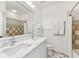 Bright bathroom with a double sink vanity, white cabinets, and tiled shower and flooring at 3311 Home Ct, Tampa, FL 33611