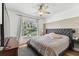 Bedroom with a large window, ceiling fan, wood floors and a stylish upholstered headboard at 3311 Home Ct, Tampa, FL 33611