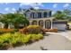 Elegant two-story home with lush landscaping, brick paver driveway, and a welcoming front porch with white columns at 3311 Home Ct, Tampa, FL 33611
