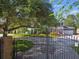 Grand home behind iron gates, surrounded by lush greenery and vibrant flowerbeds at 3311 Home Ct, Tampa, FL 33611