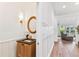 Hallway with wainscoting, gold-framed mirror in bathroom, and view into a living room at 3311 Home Ct, Tampa, FL 33611