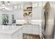 Charming kitchen with bright white cabinets, marble counters, and stainless steel fridge at 3311 Home Ct, Tampa, FL 33611