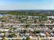 Panoramic aerial shot showcasing a residential community with homes, greenery, and a scenic lake at 3338 Hoover Dr, Holiday, FL 34691