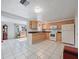 Kitchen featuring tile floors, wooden cabinets, black countertops, and white appliances at 3338 Hoover Dr, Holiday, FL 34691