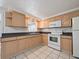 Cozy kitchen with light wood cabinets, white appliances, and ample counter space at 3338 Hoover Dr, Holiday, FL 34691