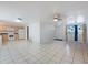 Large living area open to kitchen, featuring tile flooring and ample lighting at 3338 Hoover Dr, Holiday, FL 34691
