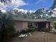 Lovely single-story home with a well-manicured lawn and beautiful landscaping around the house at 33640 Brisk Dr, Wesley Chapel, FL 33543