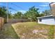 Backyard view showing a long fence, mature trees, and lawn, providing privacy and a natural setting at 4220 Oakfield Ave, Holiday, FL 34691
