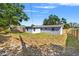 Exterior view of the backyard and the back of the house showing the fenced yard and landscaping at 4220 Oakfield Ave, Holiday, FL 34691