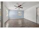 Spacious bedroom featuring a ceiling fan, wood-look floors, and a door to the backyard, perfect for a quiet retreat at 4220 Oakfield Ave, Holiday, FL 34691