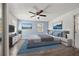 Cozy bedroom with blue accent wall, ceiling fan, wooden floors, and a door leading to the backyard at 4220 Oakfield Ave, Holiday, FL 34691