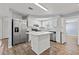 Modern kitchen features a center island, stainless steel appliances, and white cabinets at 4220 Oakfield Ave, Holiday, FL 34691