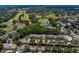 Aerial shot of a community with lush golf course, serene pond, and well-maintained residences nestled in greenery at 4240 Golf Club Ln, Tampa, FL 33618