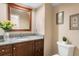 Bathroom with granite countertops, wood cabinets, and decorative framed mirror at 4240 Golf Club Ln, Tampa, FL 33618